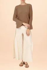 Suéter de punto con cuello perkins, color dorado con acabado brillante, de manga larga con puños acampanados y diseño de corte recto.