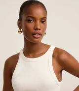 Blusa sin mangas de corte regular, confeccionada en tejido rib de algodón con cuello redondo. Presenta un diseño minimalista y anatómico, ideal para un look clásico.