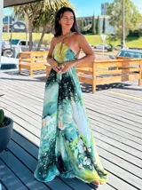 Vestido largo sin mangas con escote en V pronunciado, de corte amplio y fluido, con estampado abstracto en tonos rosados, marrones y blancos, y un cordón trenzado ajustable en la cintura.