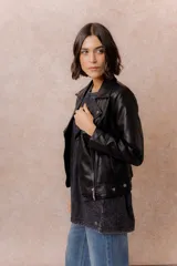Chaqueta tipo biker de cuero sintético color marrón, con cierre frontal asimétrico, cuello con solapas y broches metálicos, y bolsillos laterales con cierre.