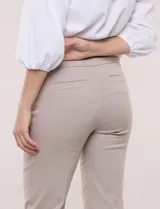 Pantalón de gabardina elastizada color beige, de tiro medio y calce slim. Cuenta con diseño pull-on sin cierres ni botones, cintura ancha, bolsillos delanteros simulados y bolsillos traseros ojal.