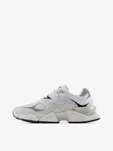 Championes New Balance modelo 9060, con diseño vanguardista inspirado en la estética Y2K. Presenta una combinación de malla y gamuza en tonos blancos y crema, con detalles en rojo y azul marino. Incluye el logo N característico en los laterales y una mediasuela robusta con tecnología de amortiguación ABZORB y SBS.