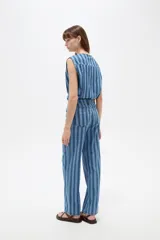 Pantalón de jean de corte recto y tiro bajo con diseño de rayas verticales en tonos azules y sutiles líneas rojas.