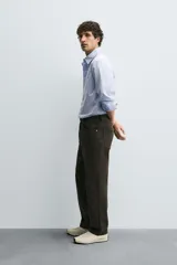 Pantalón de corte recto confeccionado en tejido de algodón con elasticidad. Presenta diseño de cinco bolsillos, cierre frontal con cremallera y botón.