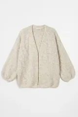 Saco abierto de punto en color beige jaspeado, con diseño de hombros caídos y mangas largas abullonadas con puños ajustados.