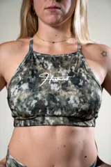Top deportivo con estampado de camuflaje en tonos verde, gris y blanco. Tiene tirantes finos y logo de la marca en el frente.