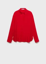 Camisa de corte recto confeccionada en tejido fluido de lyocell, con cuello camisero, cierre frontal de botones, mangas largas con puños abotonados y aberturas laterales en el ruedo.