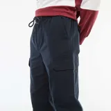Pantalón cargo de hombre, color azul marino, con cintura elástica y puños ajustados. Presenta bolsillos cargo en los laterales de las piernas.