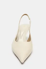 Zapato destalonado de tacón medio fino y acabado en punta, en color crudo, con tira trasera elástica.