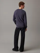 Remera de manga larga color gris de punto gofrado con cuello redondo y logo de Calvin Klein en la manga.