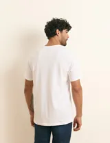 Remera básica de algodón color beige, de manga corta, con cuello redondo y un pequeño detalle bordado en el pecho.