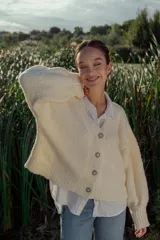 Cárdigan tejido en boucle color crudo, de corte holgado y mangas largas.