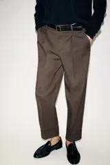 Pantalón tobillero de tiro medio con pinzas delanteras, bolsillos frontales y falsos bolsillos de vivo en la parte trasera. Presenta un bajo acabado en vuelta y se ajusta con un cinturón incluido, cierre frontal con cremallera, botón interior y gancho.