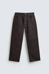 Jeans flare fit de denim negro, con tiro medio, corte ajustado en la parte superior y ligeramente acampanado desde la rodilla. Diseño de cinco bolsillos y cierre frontal con botones.