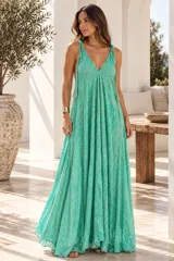 Vestido largo de corte fluido y amplio en color turquesa, con escote en V y breteles finos ajustables. Presenta un diseño artesanal con detalles bordados y textura.
