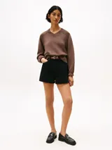 Short de denim negro de tiro alto, con corte mini flare y detalles de costura en contraste. Presenta cierre de botón y cremallera, diseño de 4 bolsillos y logo bordado de Tommy Hilfiger en el bolsillo trasero.