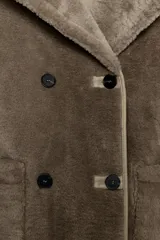 Abrigo reversible de corte recto con cuello solapa, manga larga y cierre frontal de doble botonadura. Presenta un diseño de efecto pelo en un lado y efecto piel en el reverso, con bolsillos de plastrón en el frente.