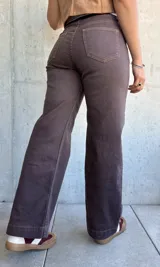 Jean de corte recto y tiro alto en color marrón chocolate, con costuras a contratono y cierre frontal con botón metálico.