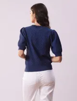 Cárdigan blanco tejido con escote en V, abertura frontal con botones y mangas cortas abullonadas con puño.