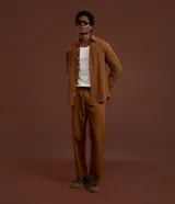 Pantalón de corte recto para hombre, color marrón, confeccionado en sarga. Cuenta con cintura con trabillas, cierre frontal tradicional y bolsillos laterales y traseros.