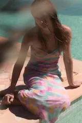 Vestido midi de tul con escote corazón y tirantes finos ajustables. Presenta frunces en el delantero y un estampado floral multicolor en tonos rosados, celestes y amarillos, con forro interior y cierre lateral con cremallera oculta.