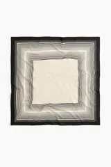Pañuelo cuadrado de gran tamaño en tejido suave con diseño estampado de marcos de líneas en blanco y negro sobre fondo beige y bordes negros.