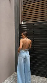 Top halter color beige, estilo chaleco corto, con cuello alto y bordes festoneados con costura decorativa.