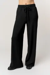 Pantalón negro de punto, de corte amplio y relajado, con cintura elástica ajustable mediante cordón y caída fluida.