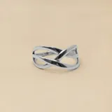 Anillo de plata con diseño de círculo y anillo de plata con diseño de líneas cruzadas.