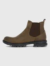 Bota estilo Chelsea color marrón, confeccionada en cuero con paneles elásticos laterales en tono marrón oscuro. Presenta una suela de goma robusta y flexible con tecnología de absorción de impactos y una tira decorativa en la parte trasera con diseño de bandera.