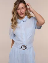 Conjunto de dos piezas confeccionado en lino, de estilo casual safari. Incluye camisa de manga corta con cuello camisero con bordado festoneado, abotonadura frontal y bolsillos en el pecho; y pantalón palazzo de tiro alto con bolsillos y cinturón con hebilla metálica dorada.