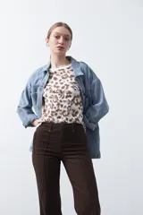 Pantalón de mujer color beige, de corte recto y tiro alto, con costuras frontales marcadas que recorren la pierna.