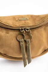 Cartera tipo bandolera de gamuza sintética color marrón, con diseño de media luna, cierre frontal con doble tirador metálico y detalle de borla lateral.