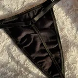 Tanga de hilo negra con tiras laterales regulables.