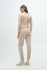Pantalón tipo jean de corte recto y tiro medio, en color beige con sutiles rayas verticales en tonos tierra.