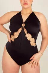 Body colaless negro de LYCRA® con breteles elásticos regulables cruzados en la espalda y detalle de aros metálicos en el frente. Tiene broche en la entrepierna con fundillo de algodón 100%.