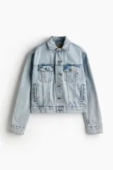 Campera corta de denim celeste con cuello clásico, botones metálicos, bolsillos superiores con solapa y bolsillos laterales.