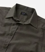 Camisa de manga larga confeccionada en tricolina de algodón, con cuello inglés, cierre frontal de botones y puños abotonados. Diseño liso y versátil.