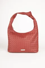 Cartera marrón de símil cuero trenzado con asa fija anudada. Cuenta con tres bolsillos interiores.