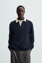 Sudadera de manga larga estilo polo con diseño de rayas horizontales anchas en azul marino y blanco. Presenta cuello de solapa en contraste, cierre frontal con botones ocultos y acabados en rib en puños y bajo.