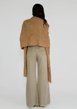 Chal de tejido de punto color crudo, con calados y flecos.