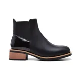 Bota corta de cuero negro con elástico lateral, detalle charol en el talón y taco bajo de madera.