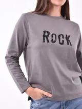 Remera de manga larga color blanco, con cuello redondo y diseño estampado en la parte frontal de hojas en color negro.