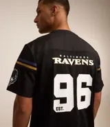 Remera deportiva negra de poliéster con tecnología Dry, cuello en V y manga corta. Estampado frontal con el número 96 y el logo de los Baltimore Ravens de la NFL.