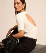 Blusa negra de viscosa con cuello redondo, mangas cortas y textura acanalada. Presenta un recorte oval en la espalda.