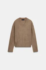 Jersey de punto con textura efecto cepillado, cuello en V y manga larga con terminaciones en rib.