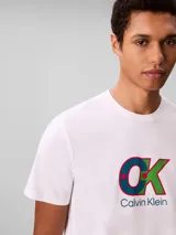 Remera de cuello redondo y manga corta, confeccionada en algodón regenerativo. Presenta un estampado gráfico frontal con el monograma de la marca en colores azul, verde y rojo, acompañado por el logo de Calvin Klein debajo.