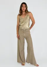 Pantalón de jean de corte ancho, color beige, con bolsillos delanteros y traseros.