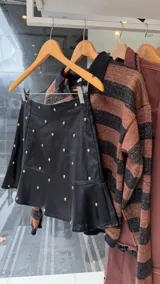 Sweater de tejido de punto con diseño de rayas horizontales en tonos marrón y negro, de corte holgado y manga larga.