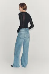 Jeans de tiro bajo y pernera flare, confeccionados en denim de algodón con efecto lavado claro. Presenta diseño clásico de cinco bolsillos, trabillas para cinturón y cierre frontal con cremallera y botón metálico.